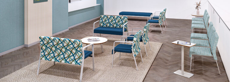 Healthcare lobby with chairs and benches in a blue and multicolor pattern upholtery.