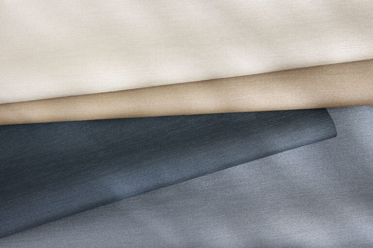 A coated material with a silk-like texture in four different color variations stacked on top of each other.