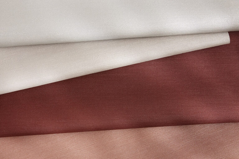 A coated material with a silk-like texture in four different color variations stacked on top of each other.