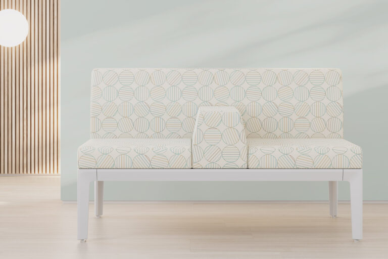 A healthcare bench seat with a pattern of round multi-colored circles in front of a white wall and behind that a wood slate wall.