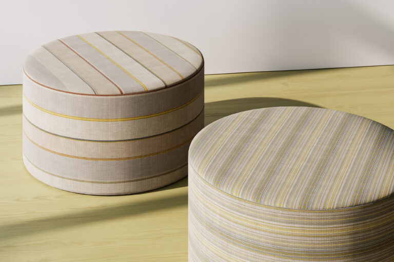 Two round ottomans with stripe patterns in a white room with wood floors.
