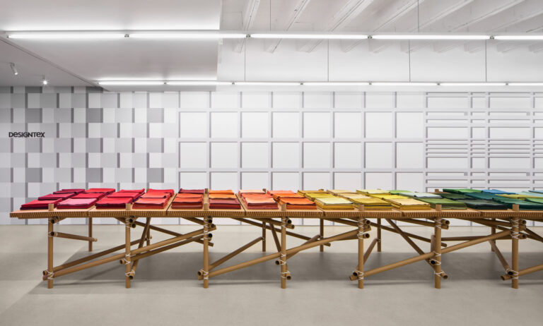 A photo of a table with stacks of colorful fabrics placed on top.