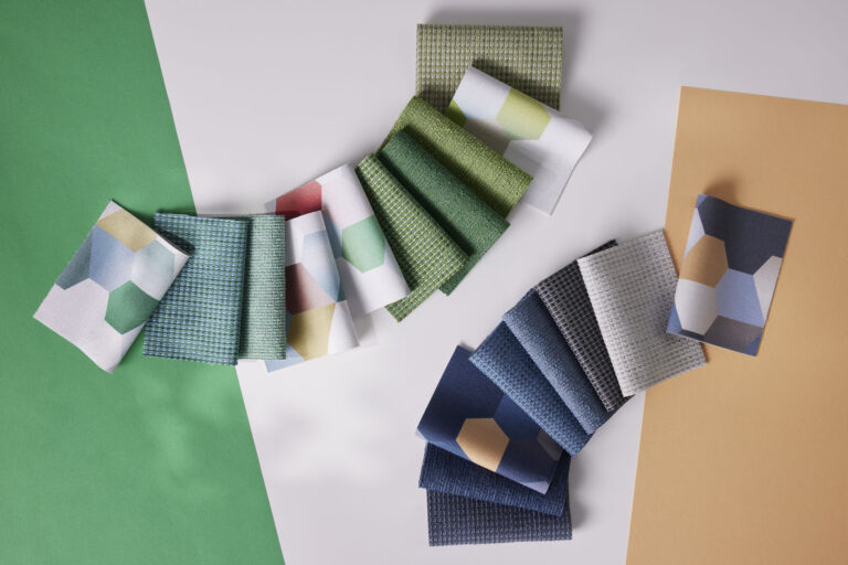 Swatches of colorful fabrics are laid out on a table.